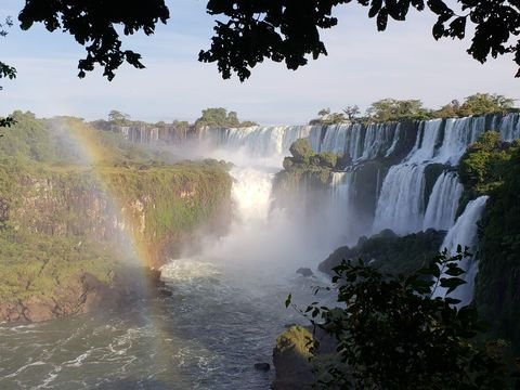 Iguazú Falls with a rainbow over the cascades and subtropical forest, Misiones
