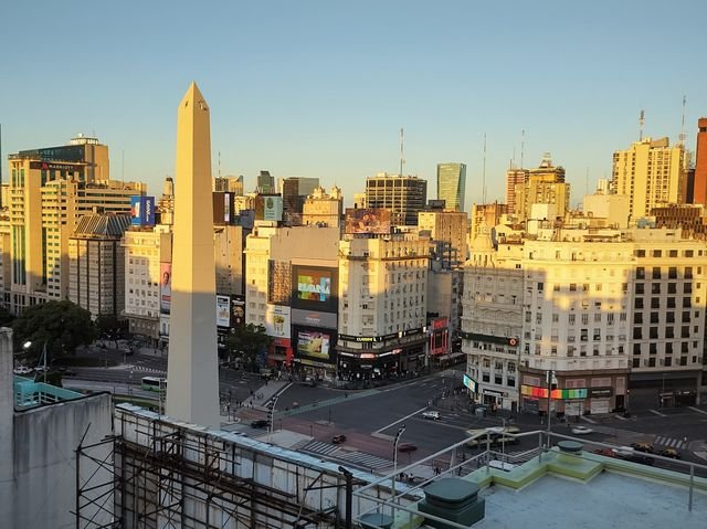 The Obelisk of Buenos Aires at golden hour, seen from above with Avenida Corrientes and Diagonal Norte